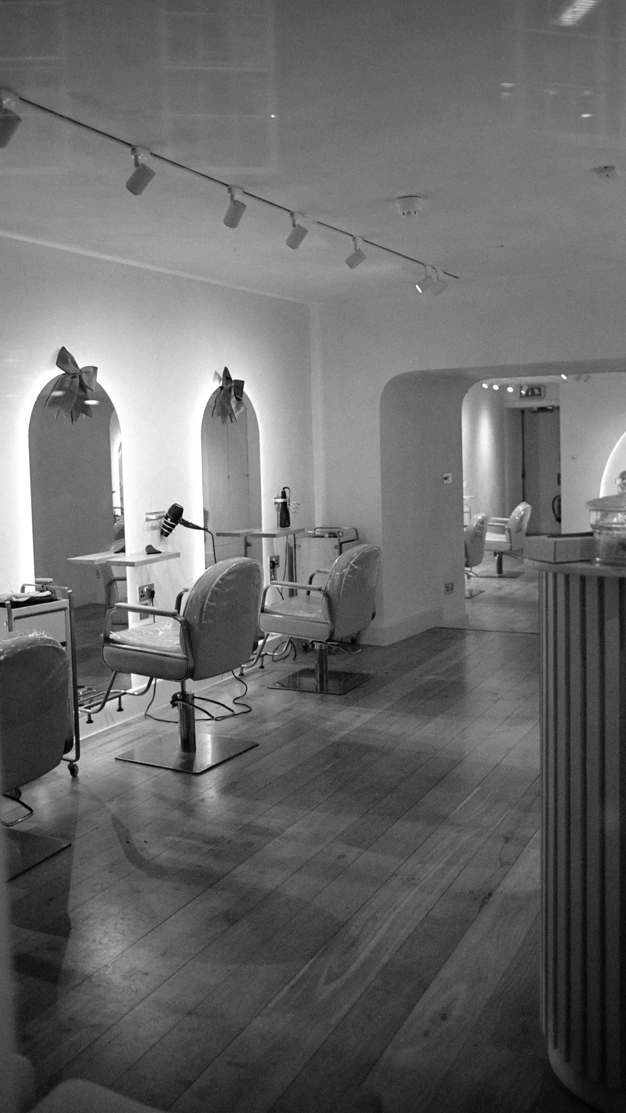 Le salon : fauteuils, miroirs et parquet clair.