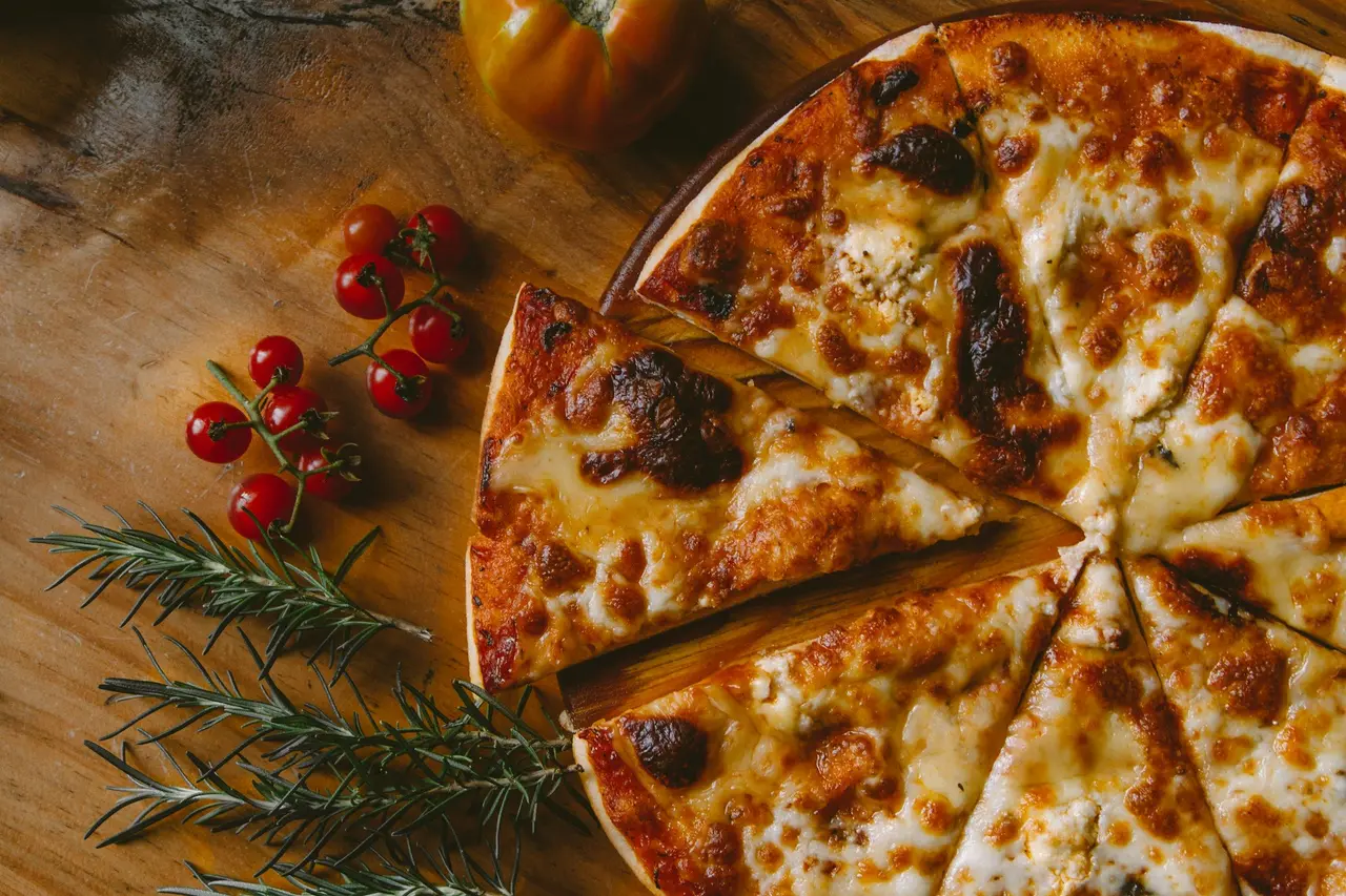 Pizza au fromage, tomates cerises et romarin, vue du dessus.